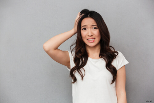 Brunette woman holding the side of her head